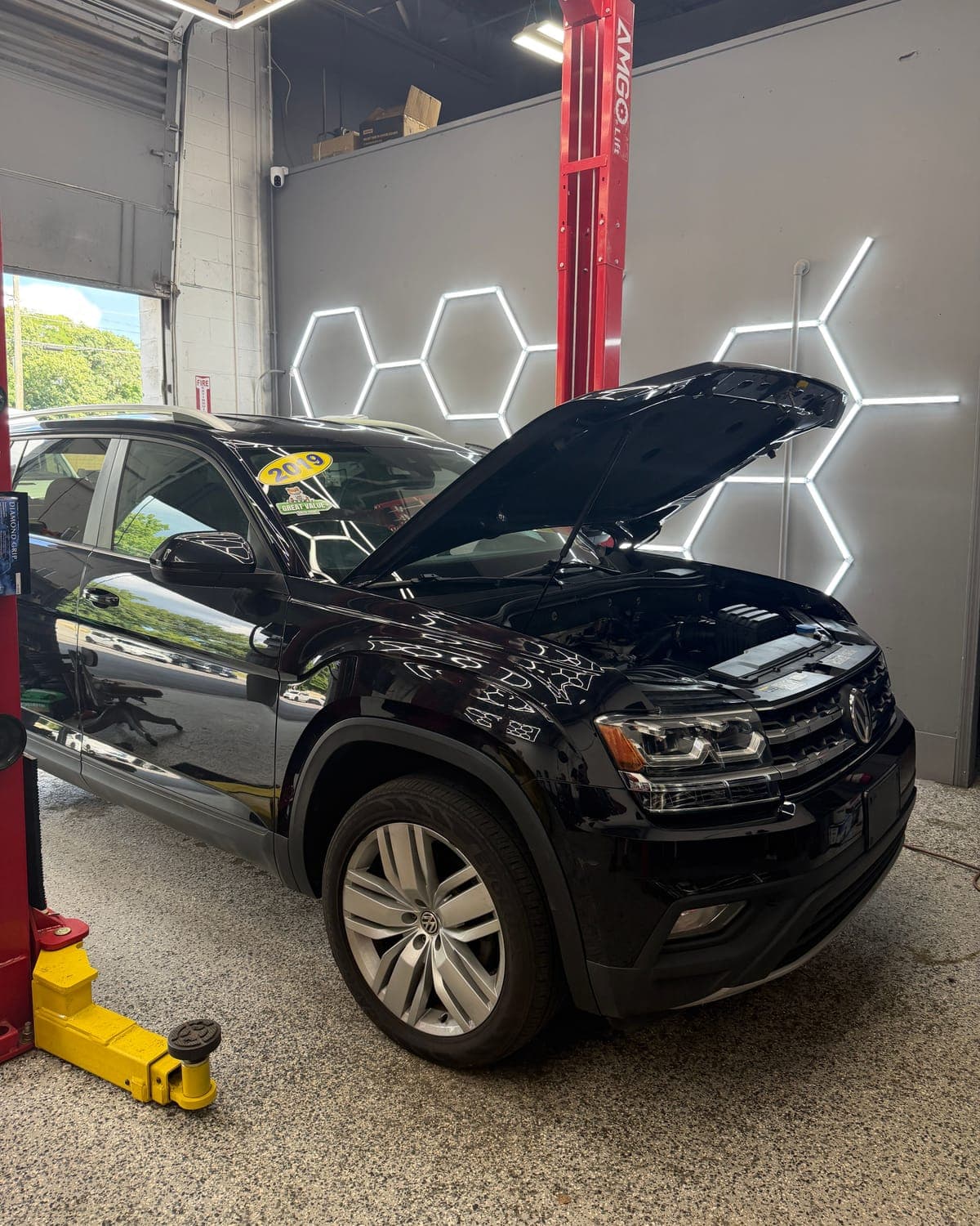 Black 2019 Volkswagen Atlas with its hood open in the Pro Tech Auto bay in Manchester, NH.